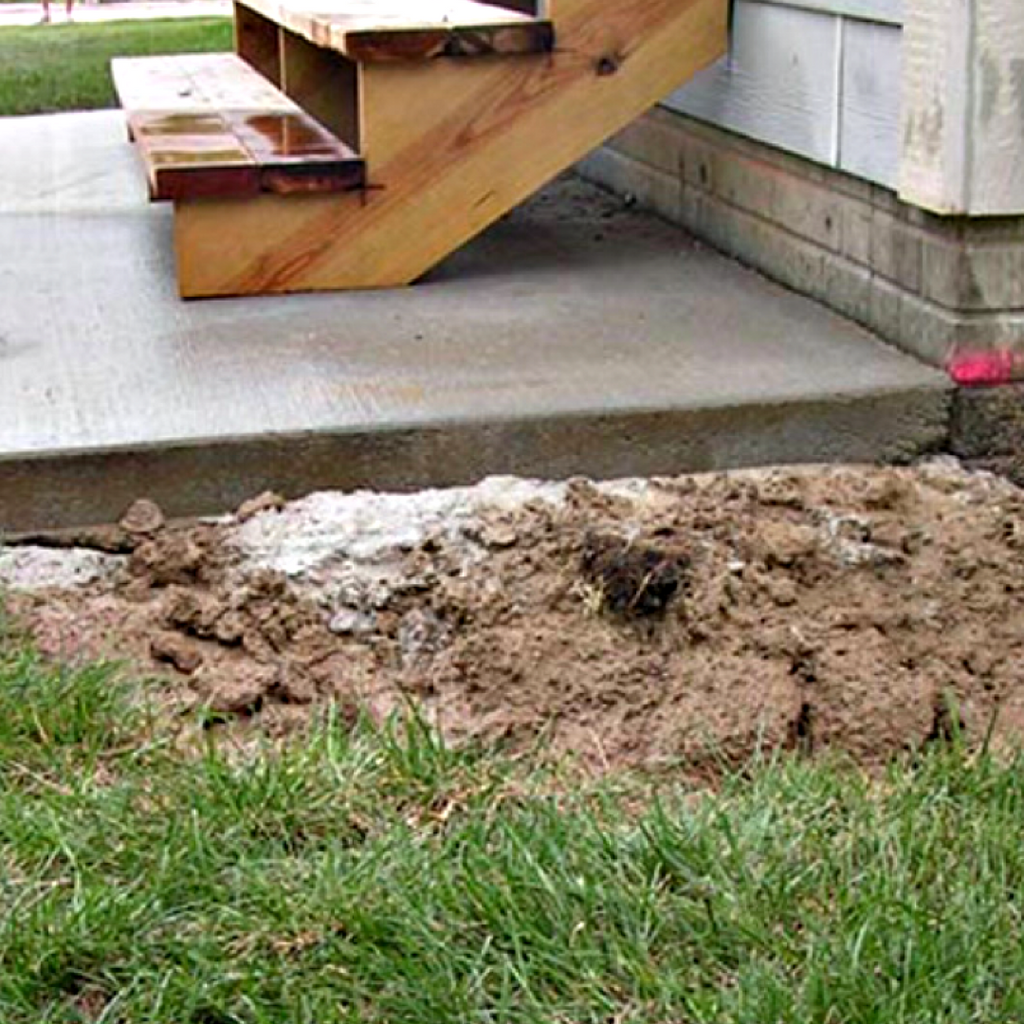 A concrete slab has the soil around it replaced after the void beneath the concrete had been filled.