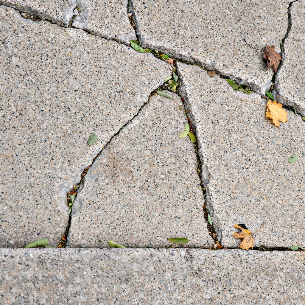 A surface of concrete that is severely damaged by cracking and settling.
